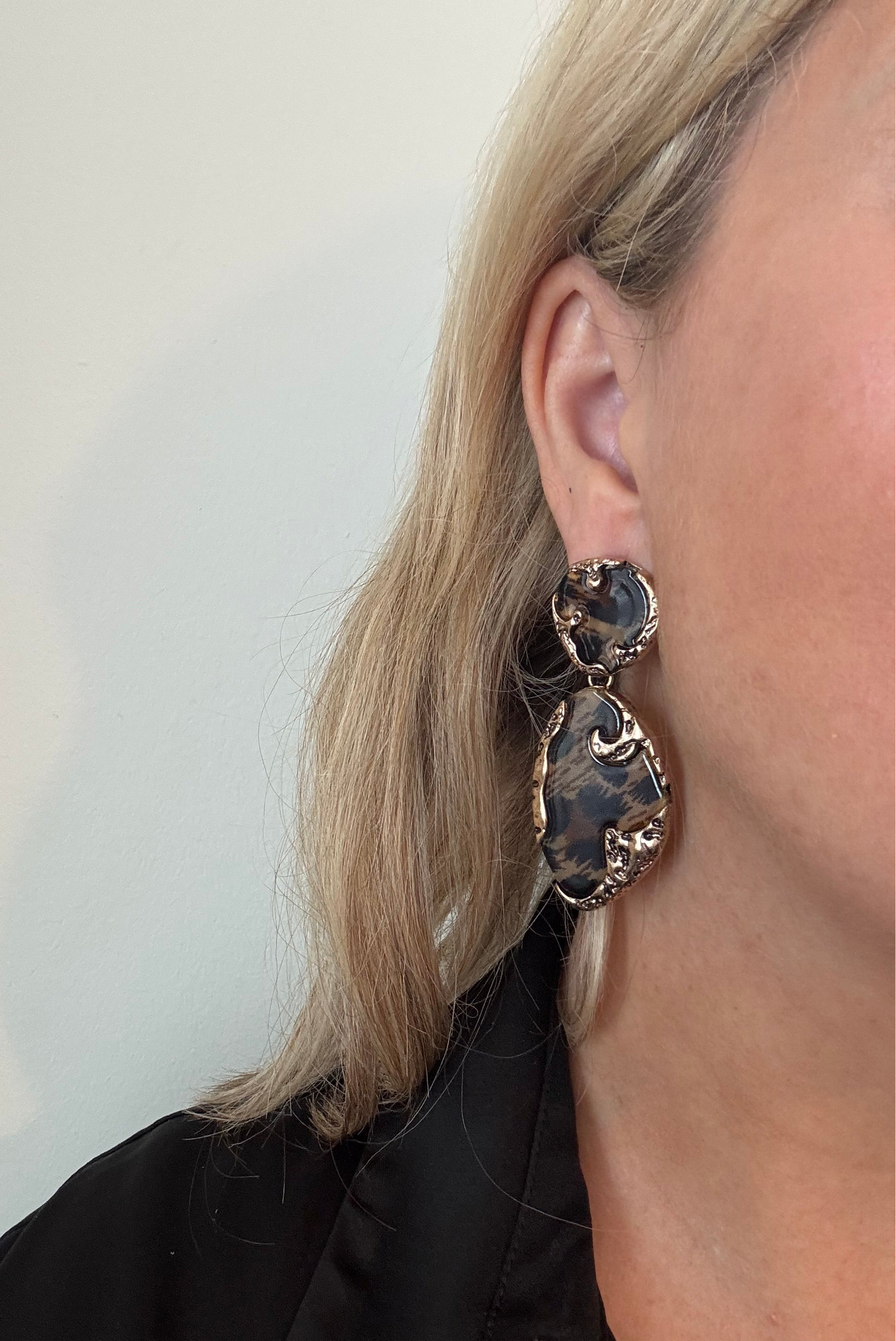 Model wearing leopard print earrings